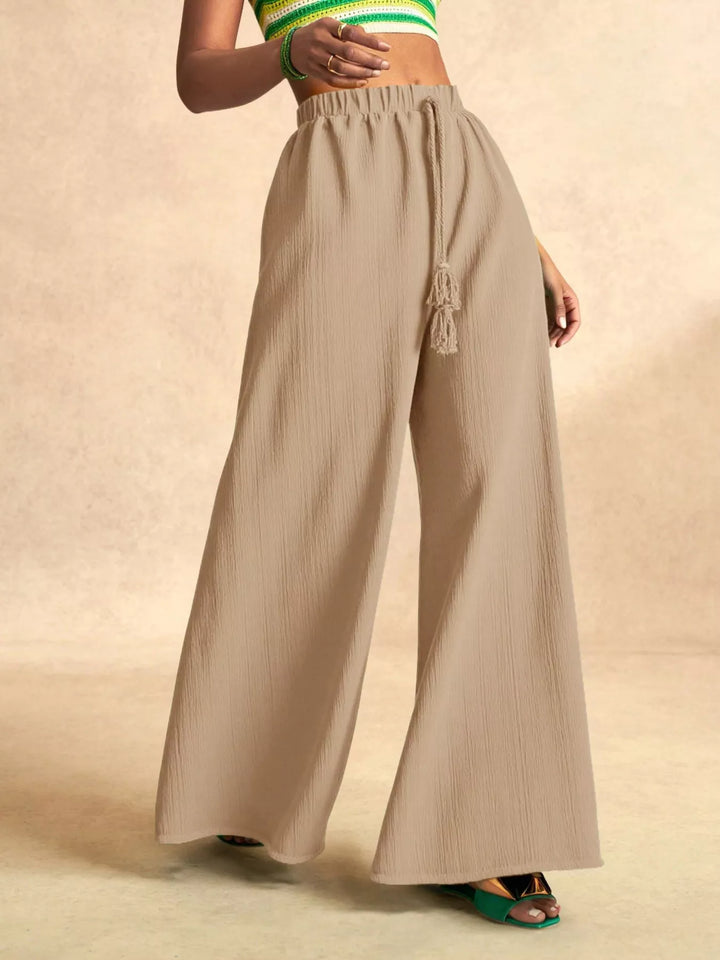Beige palazzo pants with an elastic waist and tassel tie, front view