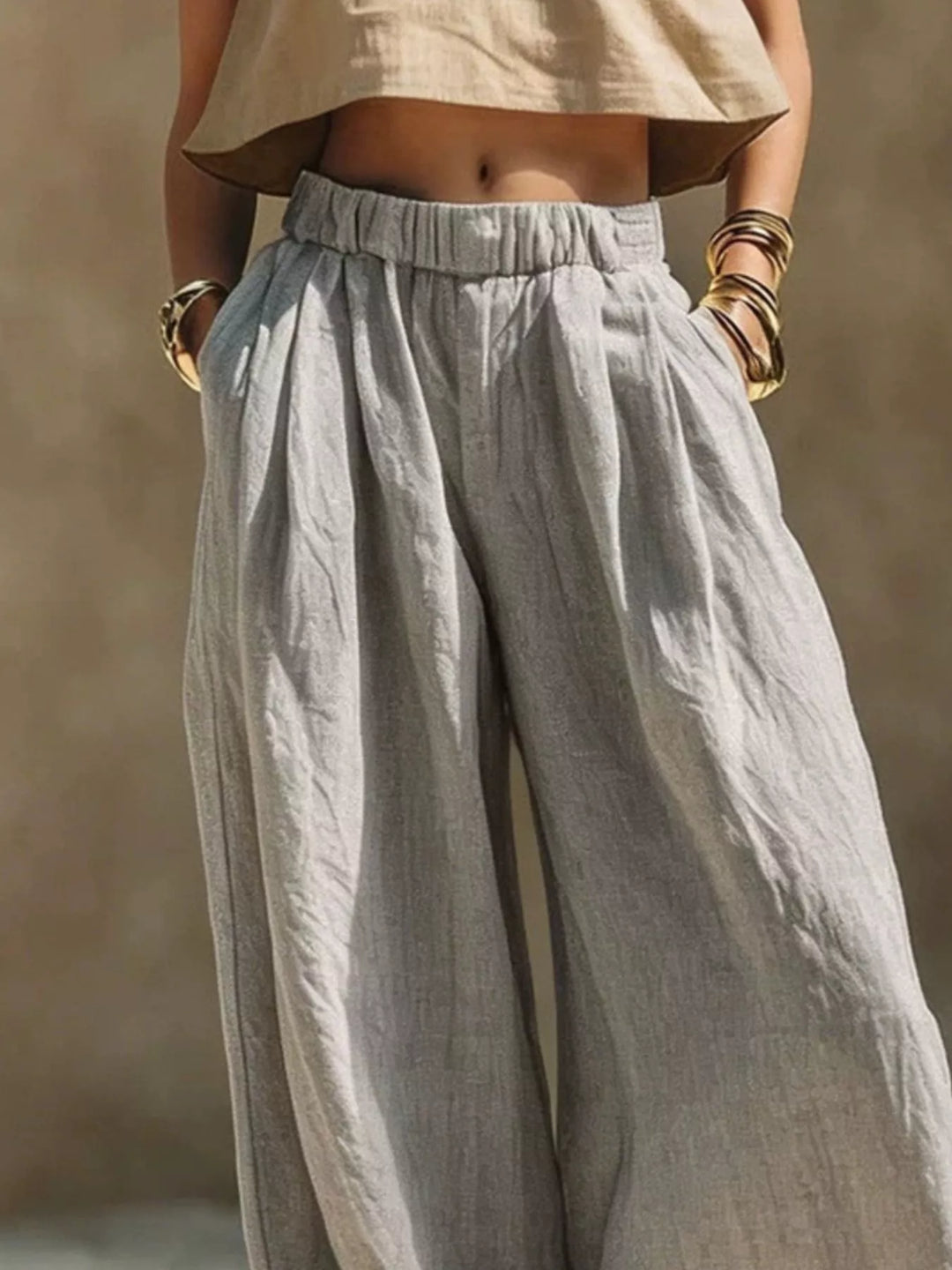 Gray palazzo pants close-up of the pleated elastic waist and hands in pockets