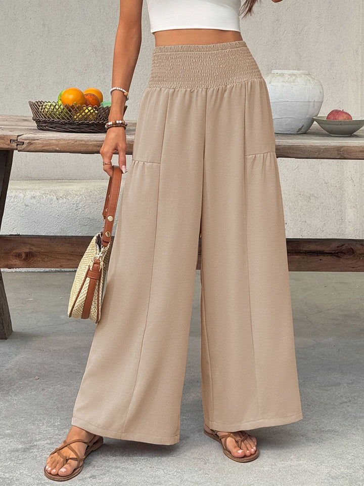Tan palazzo pants styled with a cream crescent shaped bag