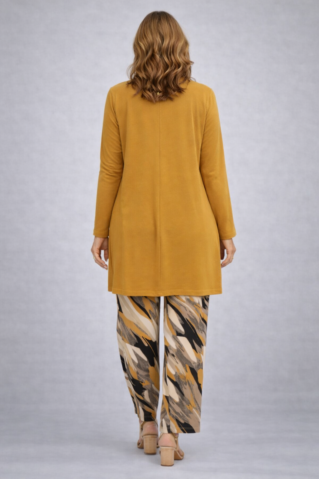 Back view of the long mustard cardigan with a center seam and wide leg pants