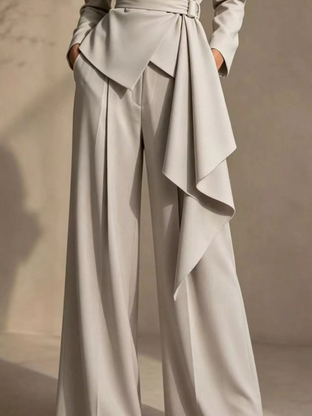 Beige pant suit close-up of the draped belt panel over the wide leg pants