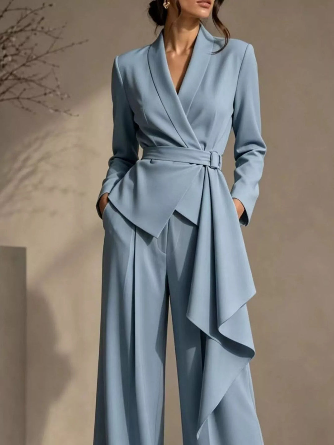 Light blue wrap blazer with belt and asymmetric ruffle drape, close-up of the pant suit