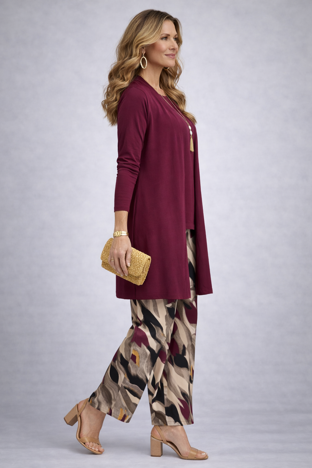 Side view of the burgundy cardigan and the beige, black and berry print pants