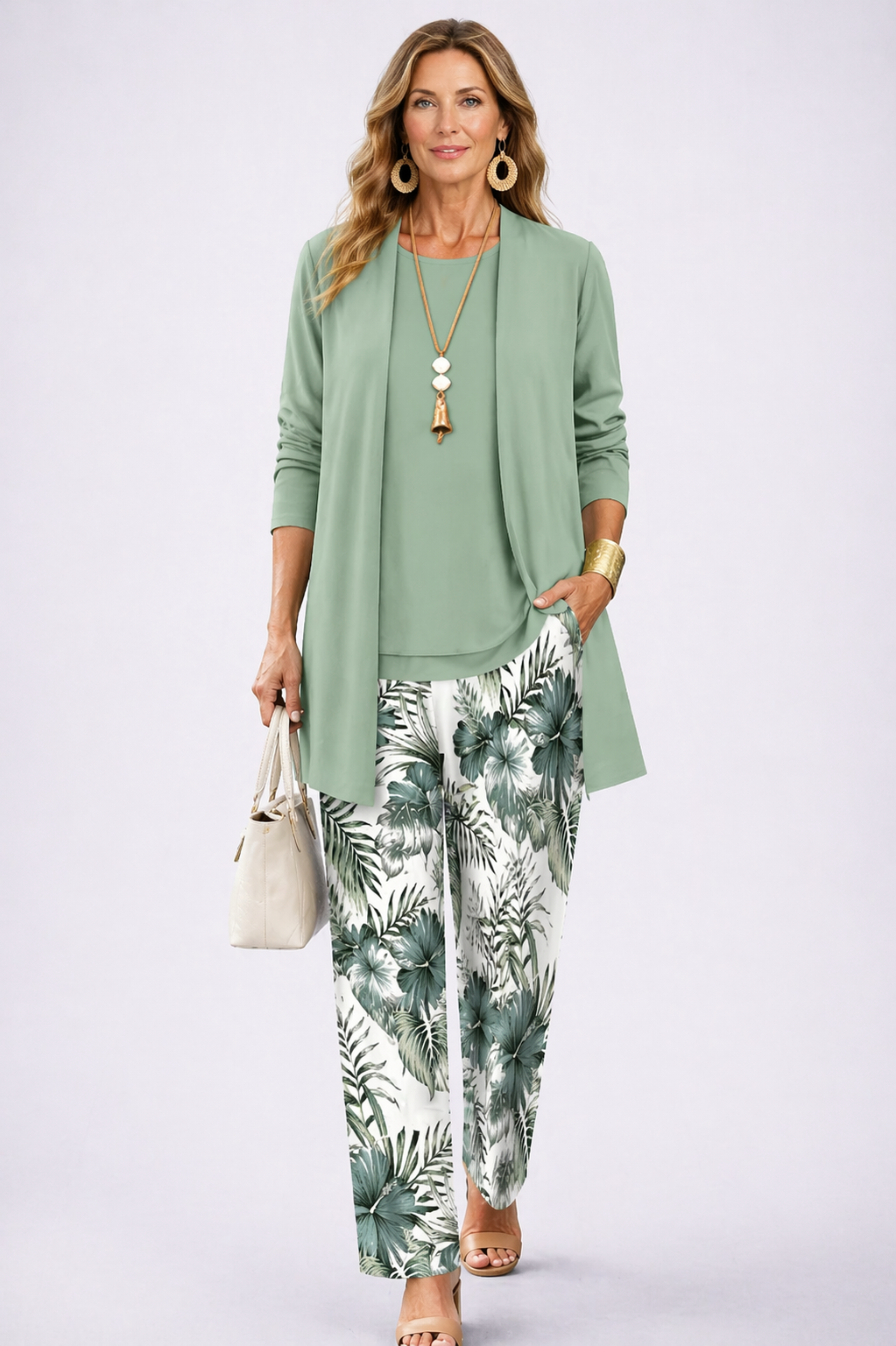 Women's pant suit in sage green with an open cardigan, curved hem top and palm leaf print pants