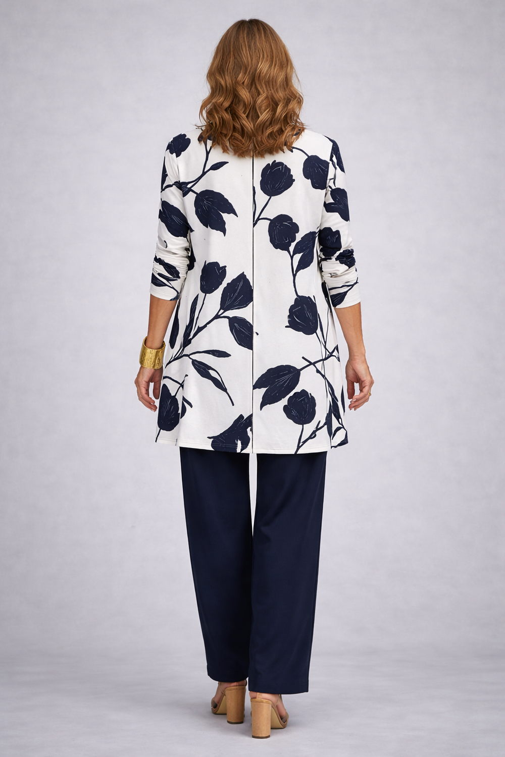 Back view of the tulip print cardigan with its center seam over navy pants