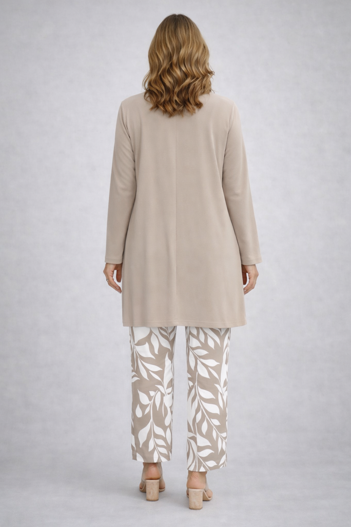 Back view of the beige cardigan with a center seam over white and beige print pants