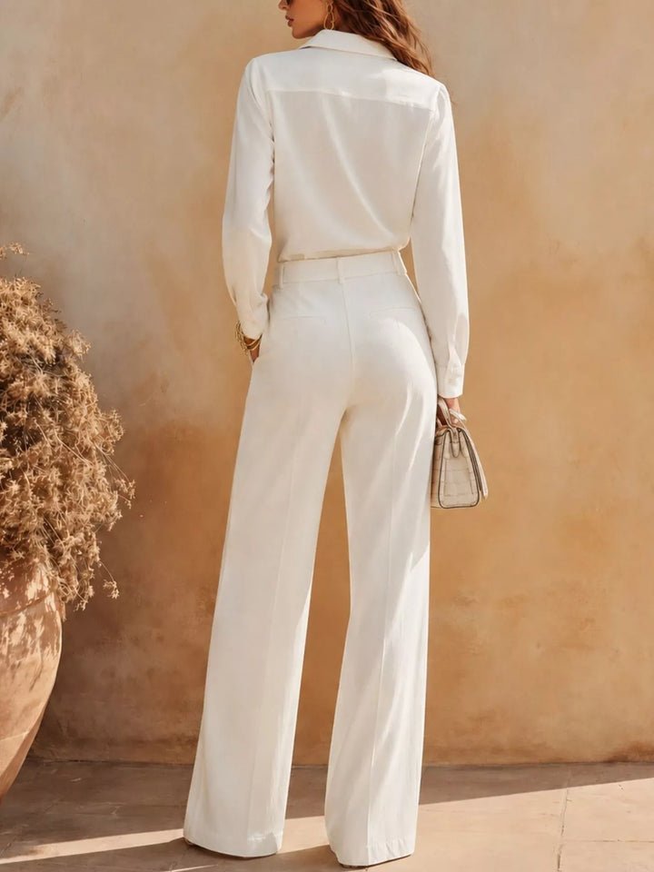 Back view of the white shirt and high waist pants set holding a small bag