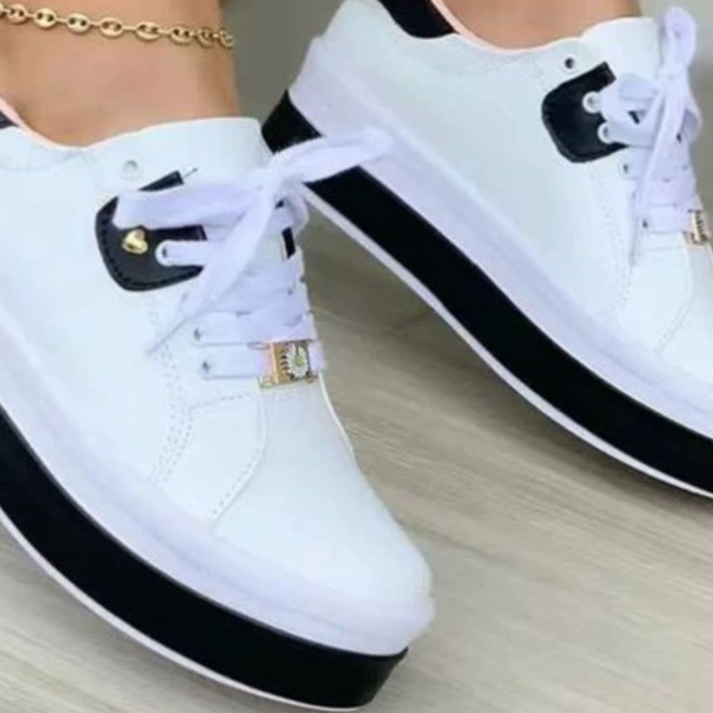 Close-up of white platform sneaker with black sole and heel tab charm