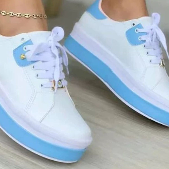 Close-up of white sneaker with light blue platform sole and heel tab