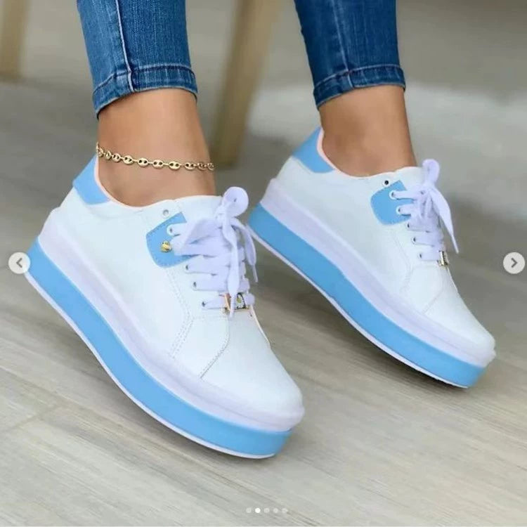 White and blue chunky platform sneakers with laces worn with cuffed jeans
