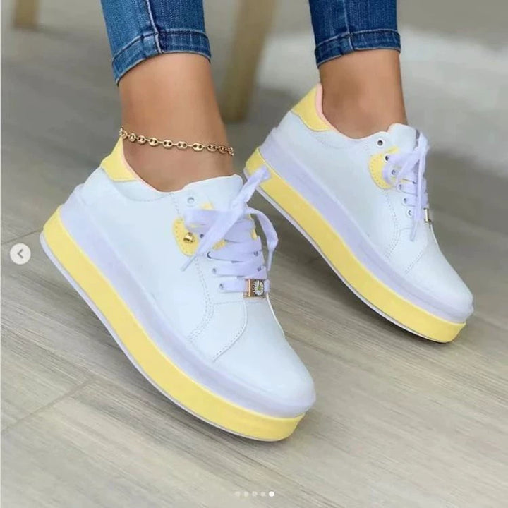 White and yellow platform sneakers with chunky sole worn with an ankle bracelet
