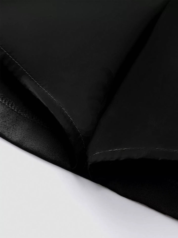 Close-up of the black skirt pleat folds and inner hem