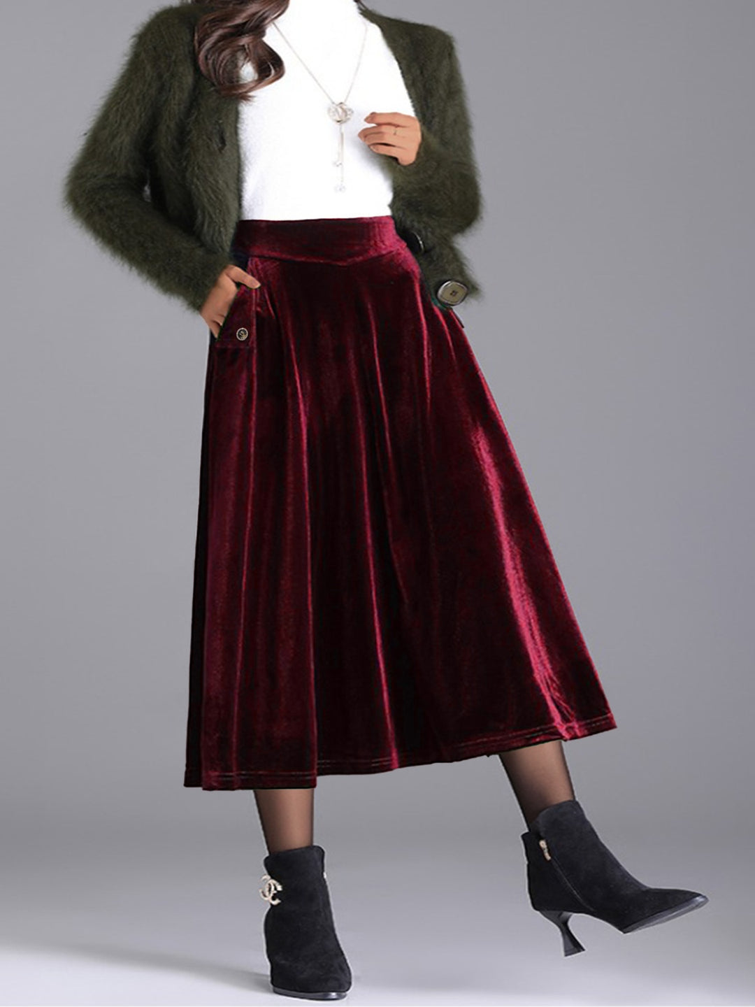 Burgundy velvet-look pleated midi skirt with white top, green cardigan and black boots