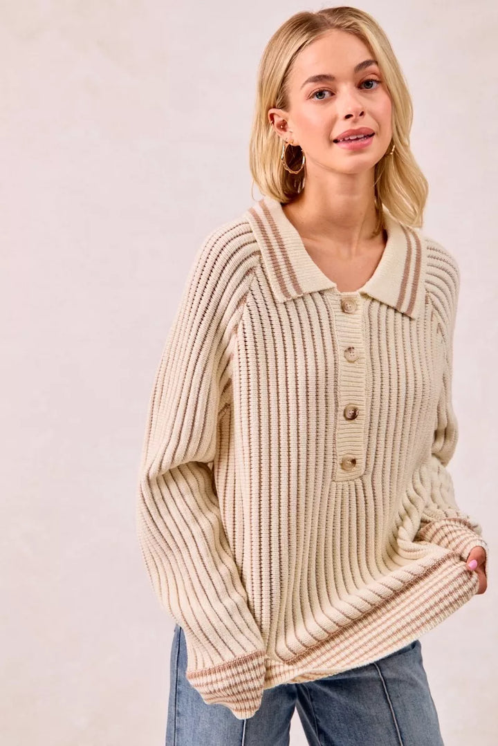 Cream latte polo sweater button placket and collar, hand holding the hem