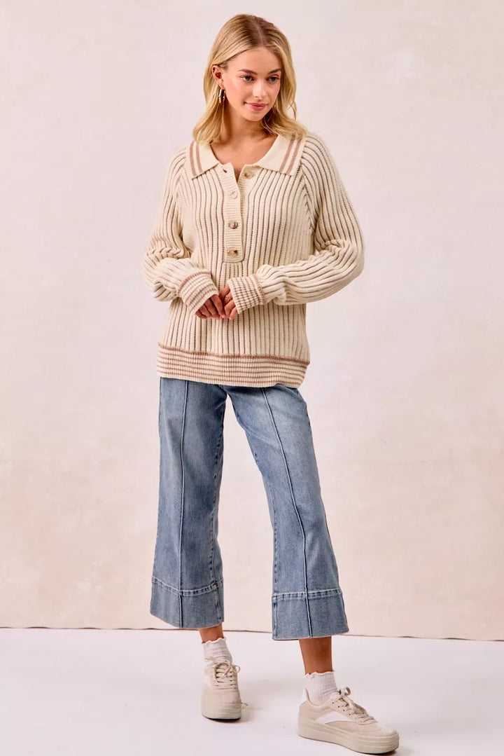 Full length view of cream polo sweater with cropped wide leg jeans and sneakers
