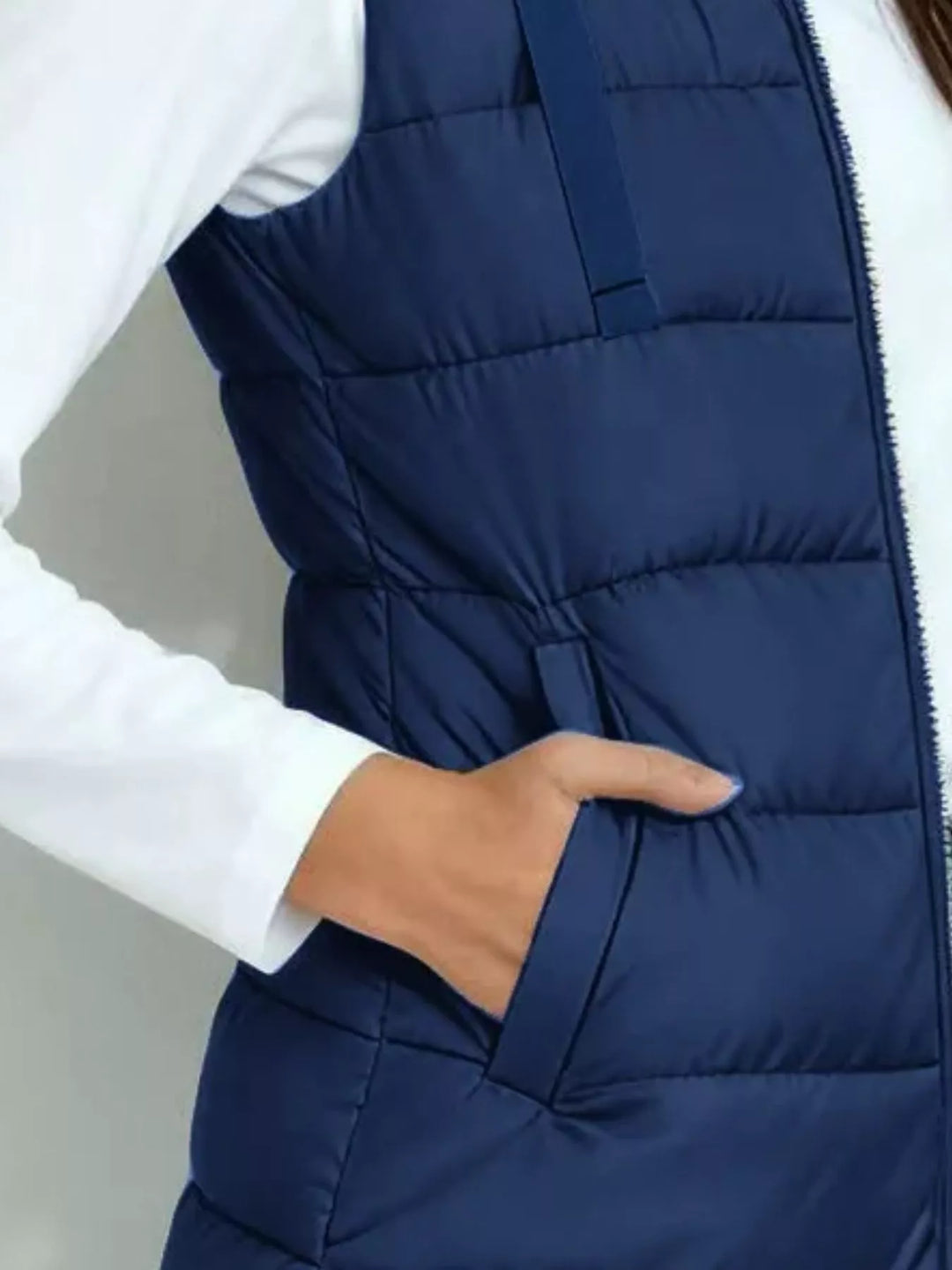 Close-up of the deep blue quilted vest side pocket