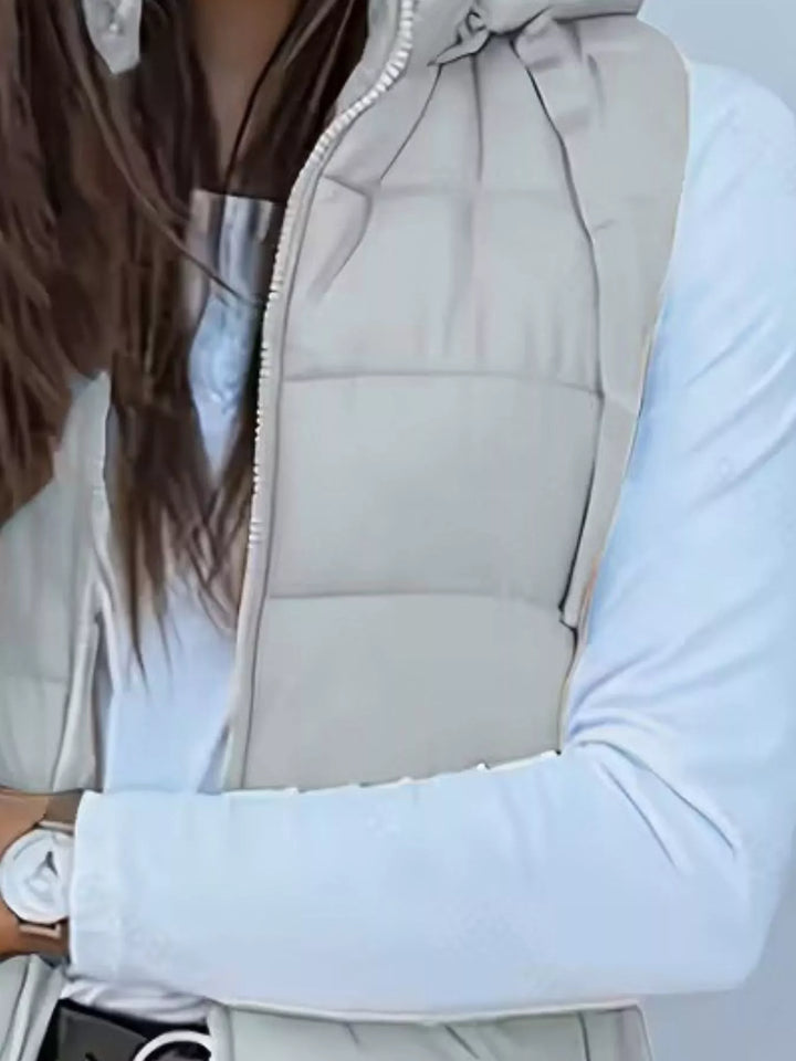 Close-up of the light gray quilted vest front over a white long sleeve
