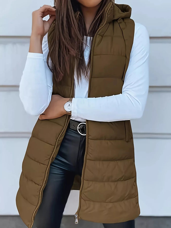 Olive brown longline hooded puffer vest worn open with black leather pants