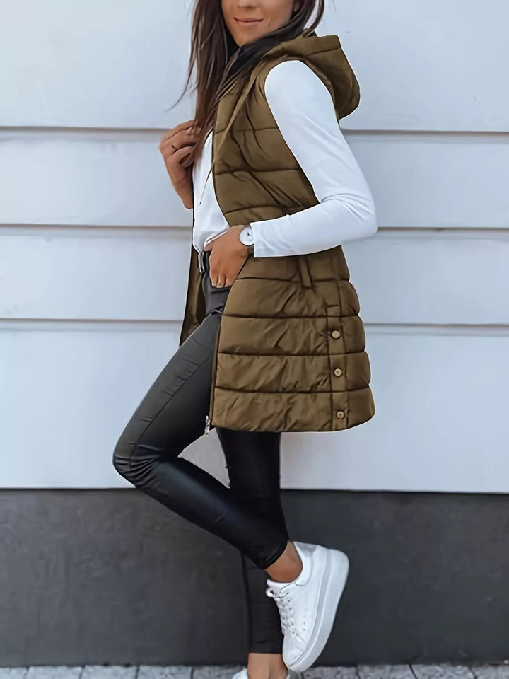 Side pose in the olive brown quilted vest with white sneakers