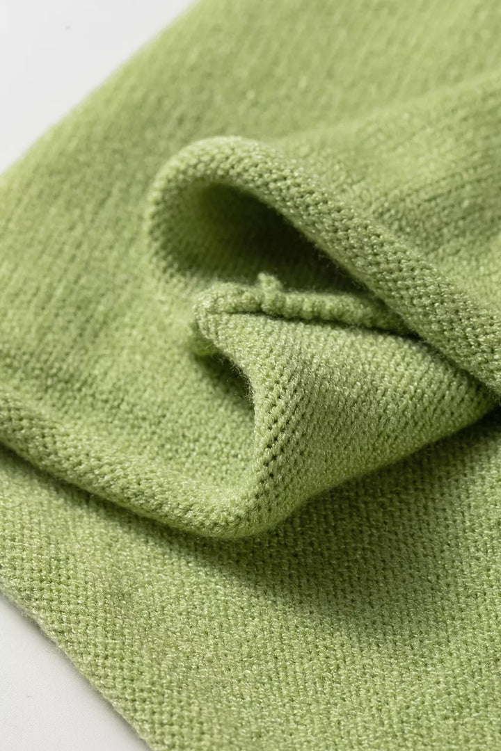 Folded detail of the pistachio green knit with a rolled hem