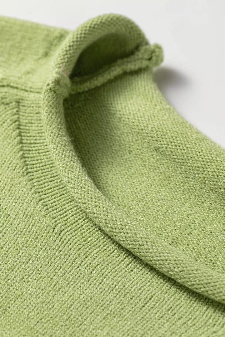 Close-up of the rolled crew neck edge on the pistachio green sweater
