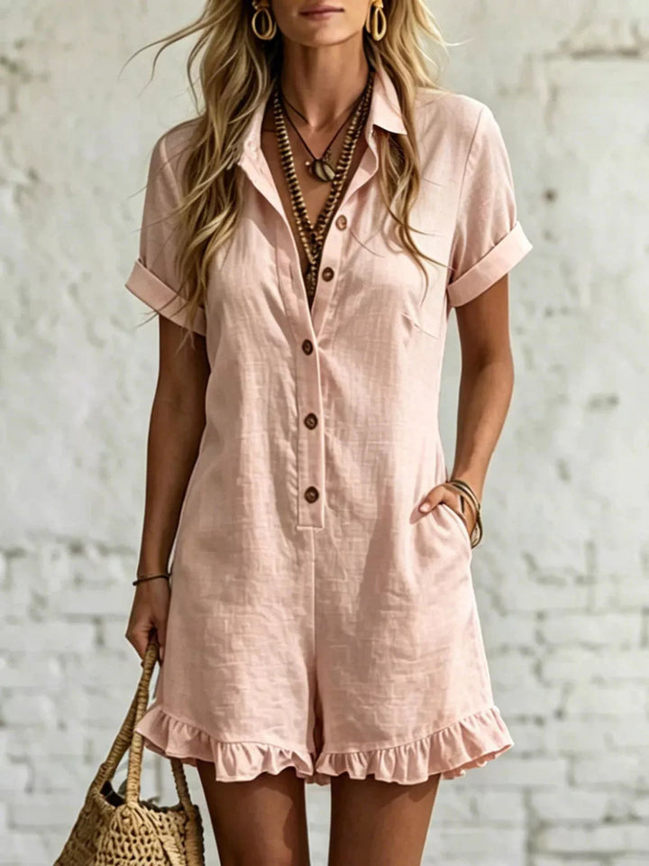 Blush pink button front romper with rolled short sleeves and ruffle hem