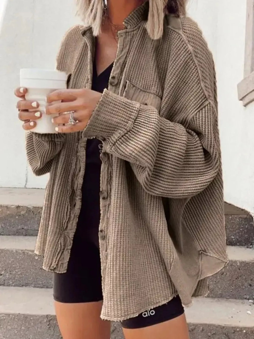 Khaki shacket styled casually outdoors on steps with black bike shorts