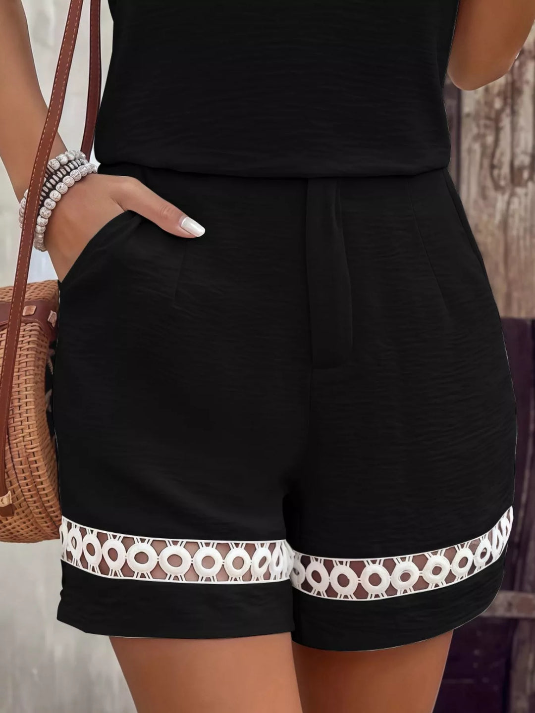 Black shorts with crochet lace trim hem and side pocket, close-up