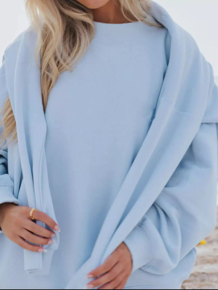 Close-up of the sky blue oversized sweatshirt pulled around the shoulders