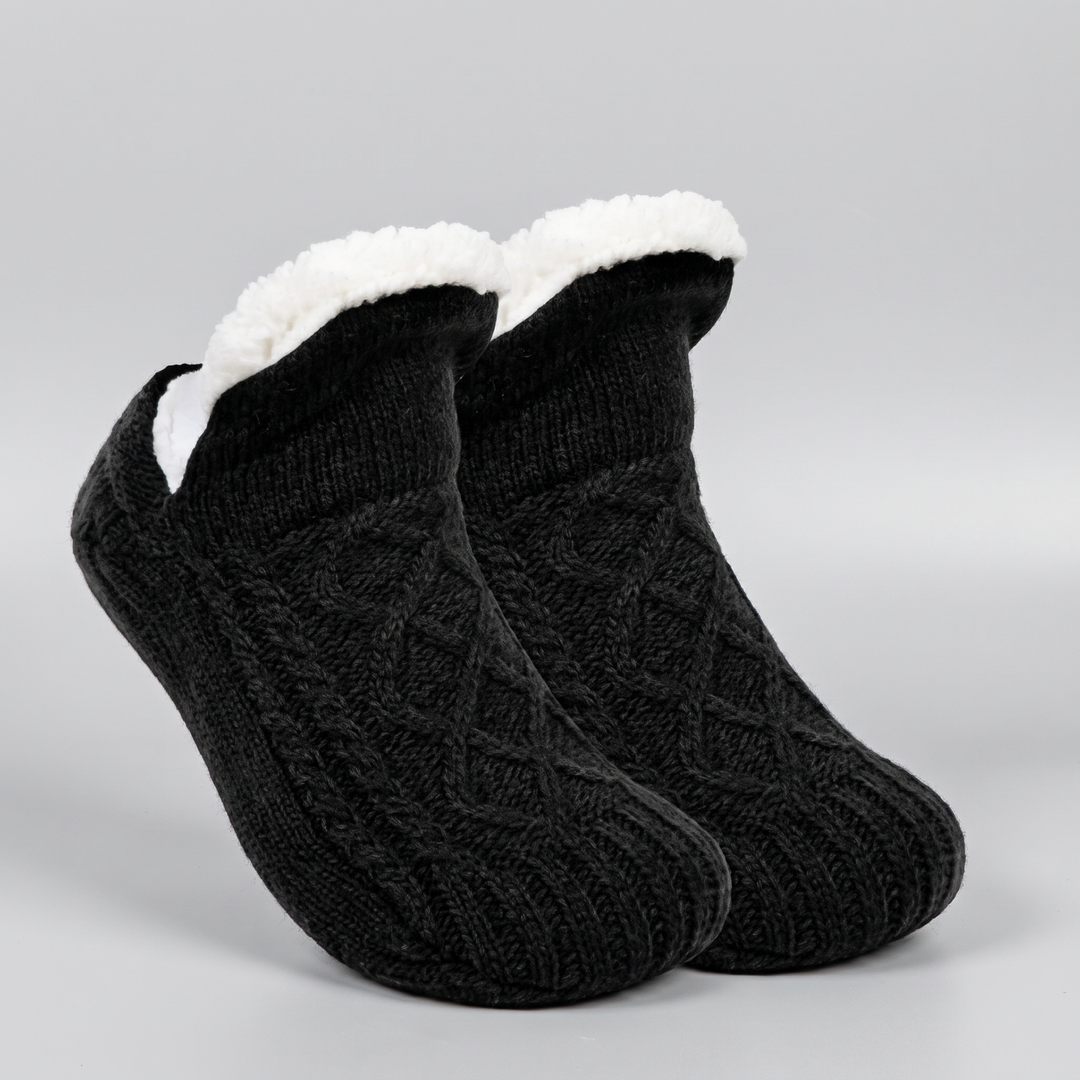 Pair of black cable knit slipper socks with folded fleece cuff