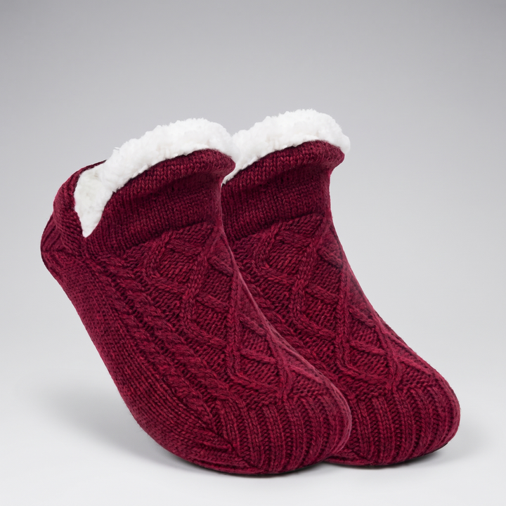 Pair of burgundy cable knit slipper socks with folded fleece cuff