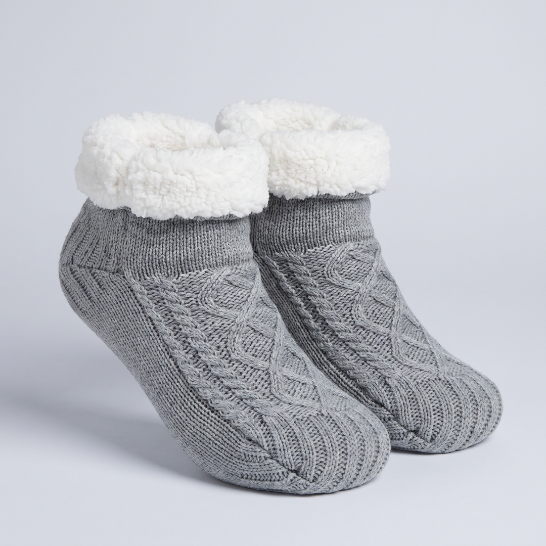 Pair of gray cable knit slipper socks with tall fleece cuff