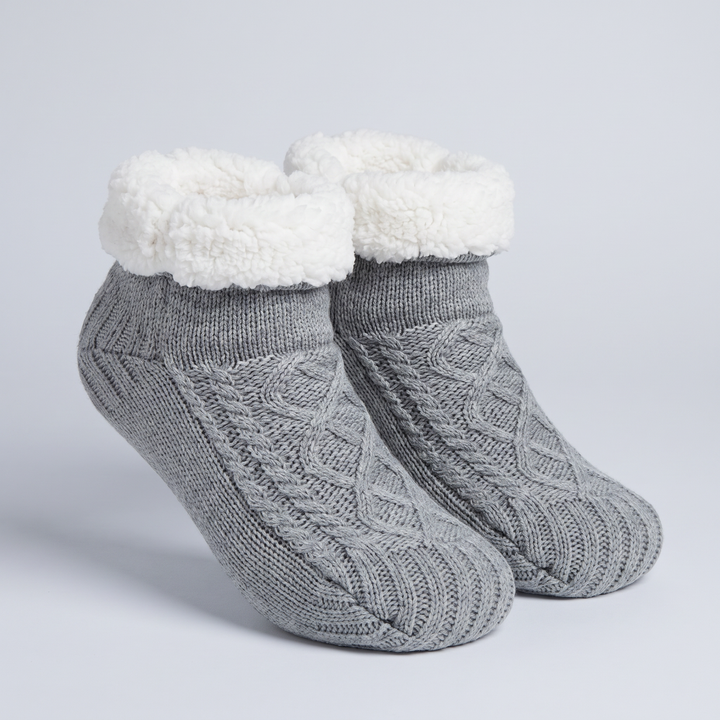 Pair of gray cable knit slipper socks with tall fleece cuff
