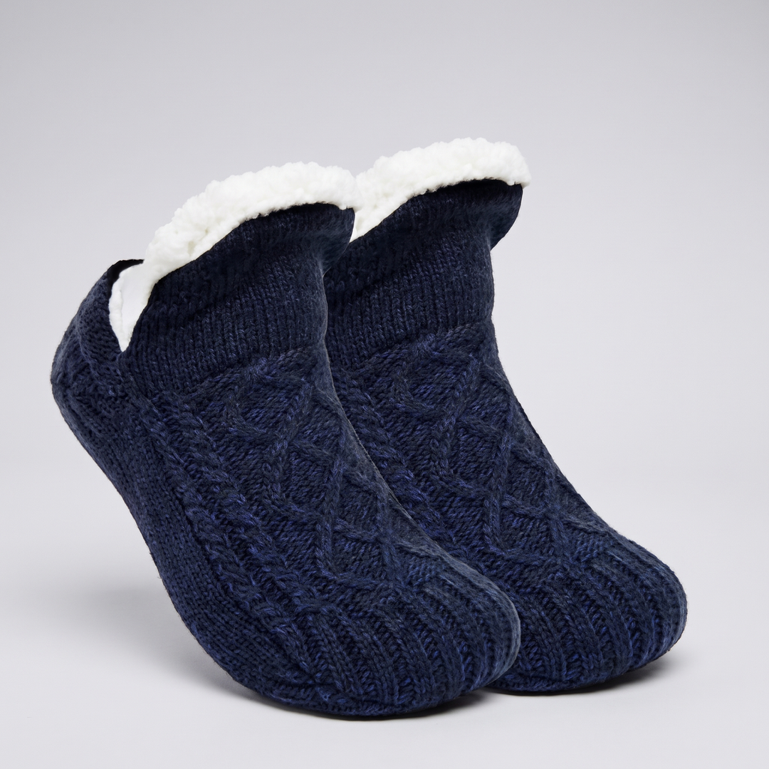 Pair of navy cable knit slipper socks with folded fleece cuff