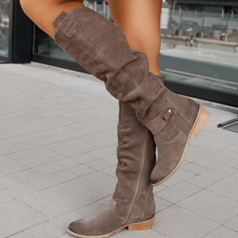 Grey knee high boot from the side with inner zip and stacked heel