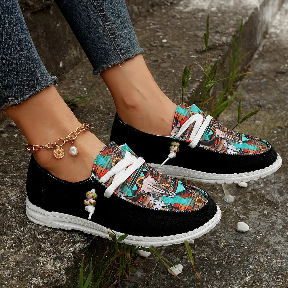 Black bull print slip on sneakers with white laces, worn outdoors on rocks