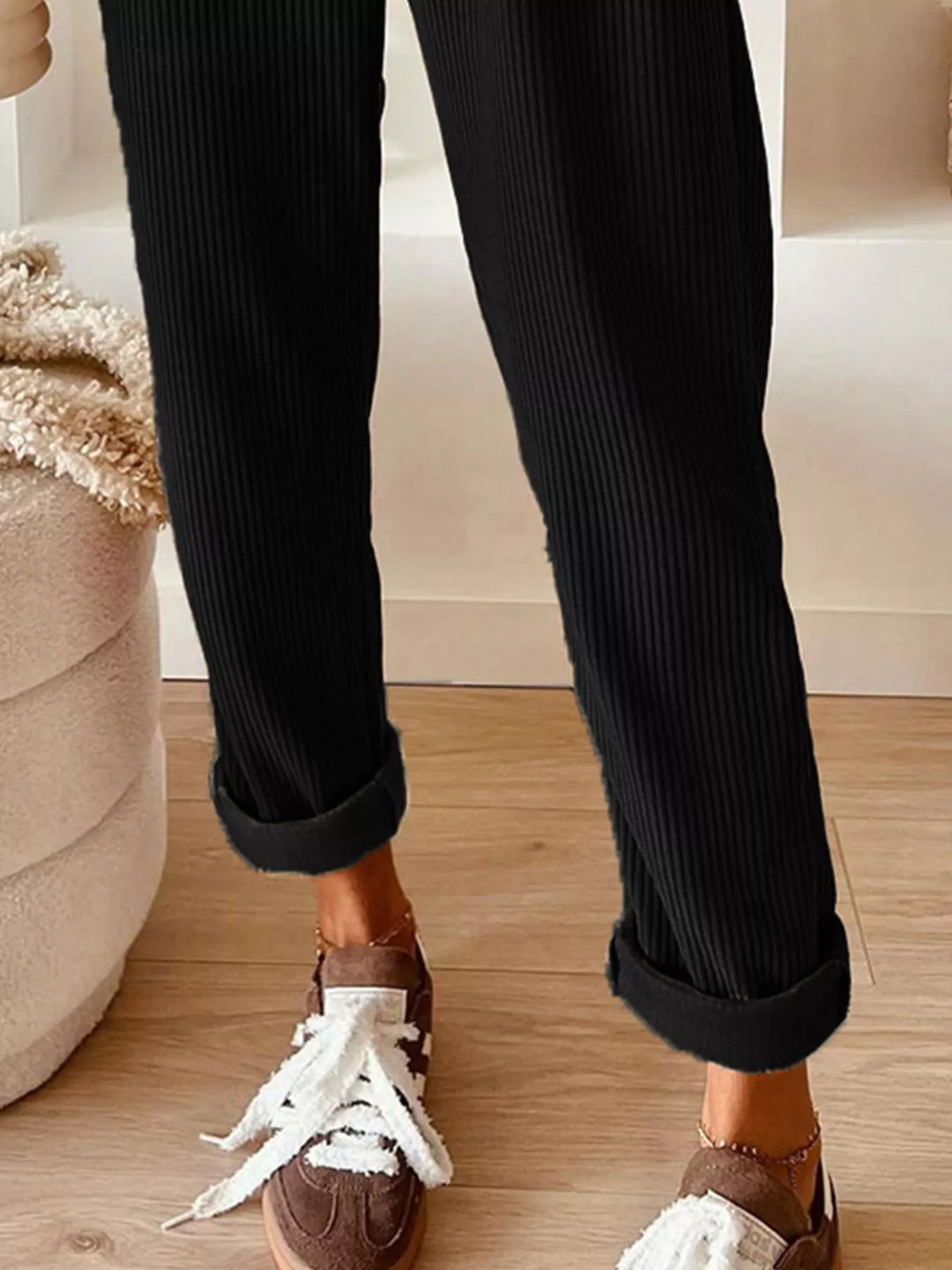Black straight leg pants with cuffed ankle and white sneakers