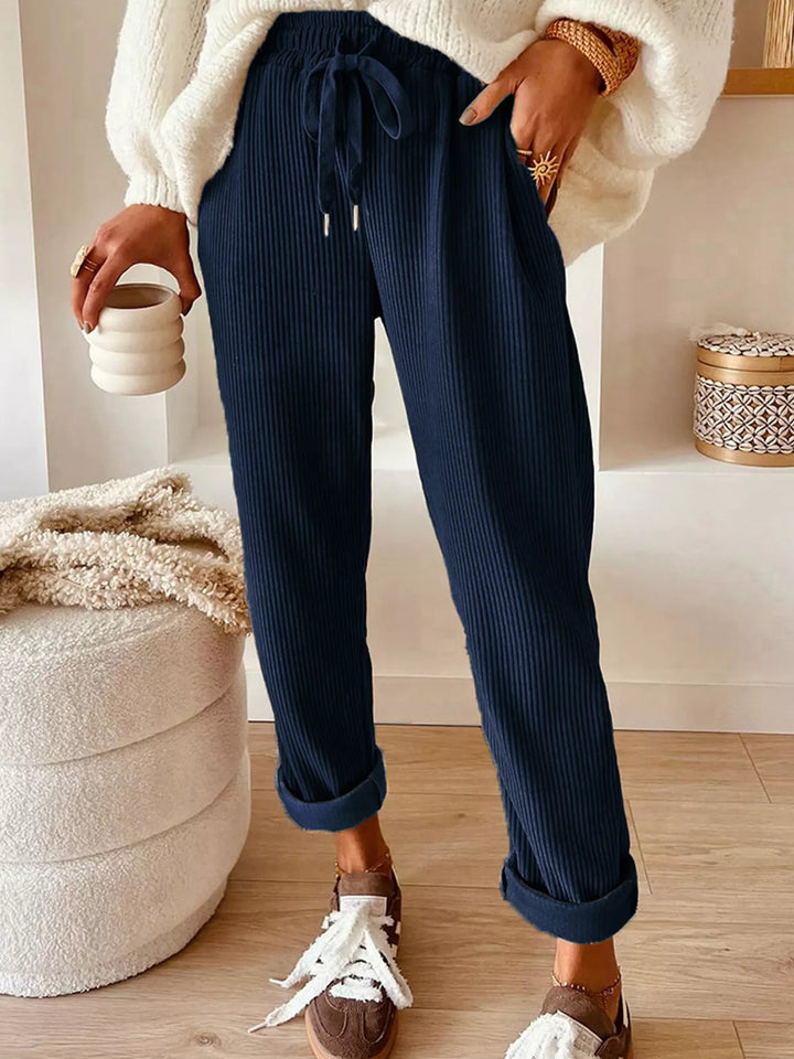 Navy ribbed straight leg pants with drawstring waist, worn with a cream sweater