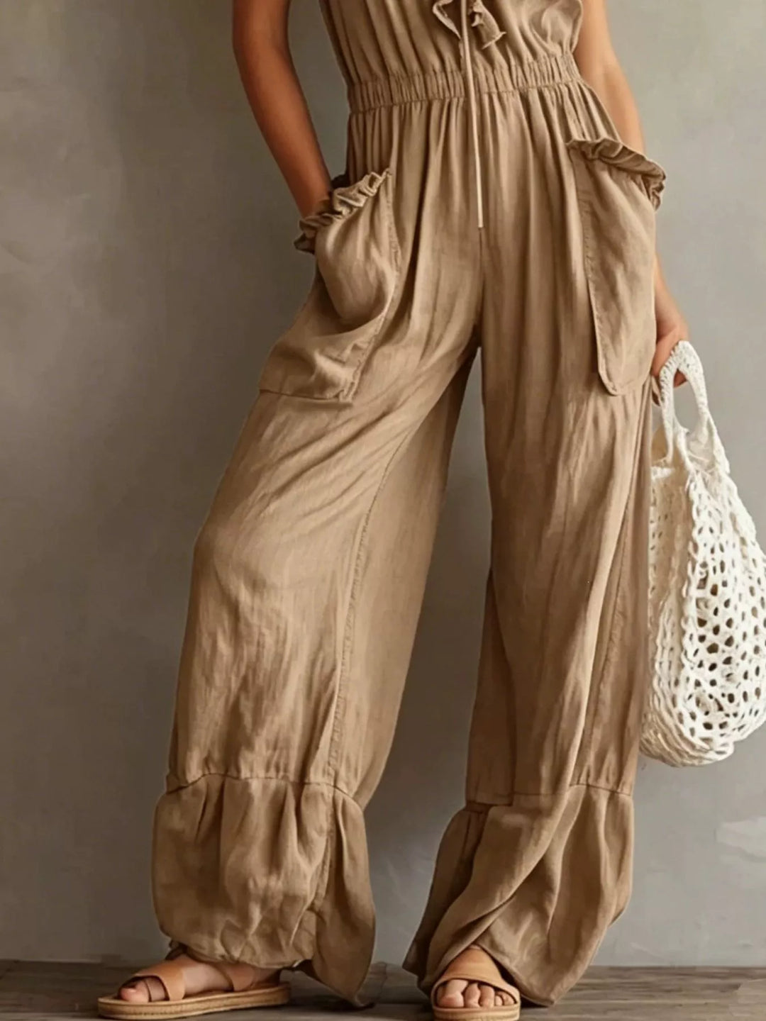 Tan jumpsuit lower view showing the wide leg and gathered ankle hem