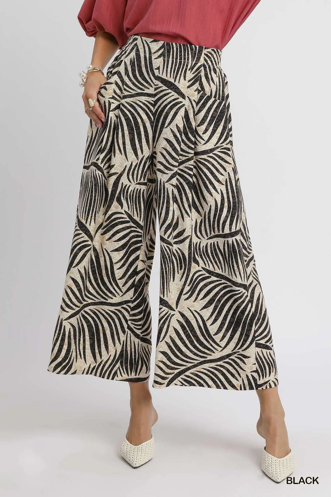 Women's summer pants in black palm print, cropped wide leg culottes, front view with white heels