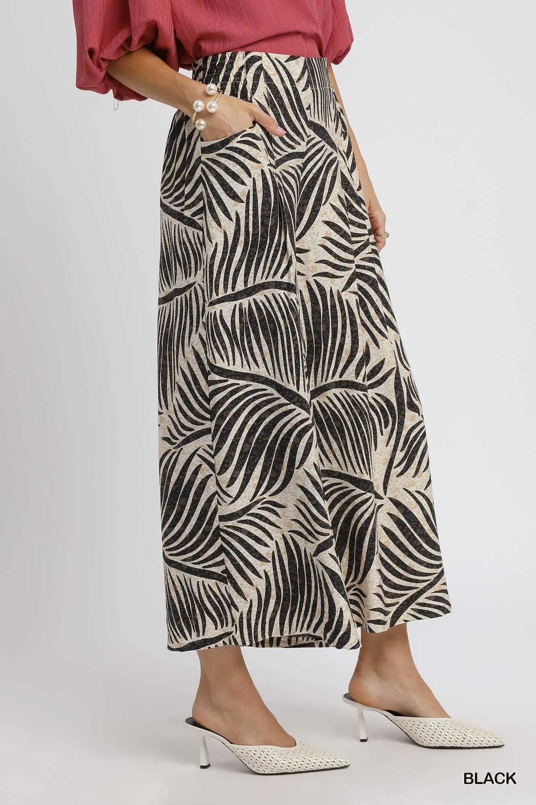 Side view of the cropped wide leg palm print culottes with pointed mules