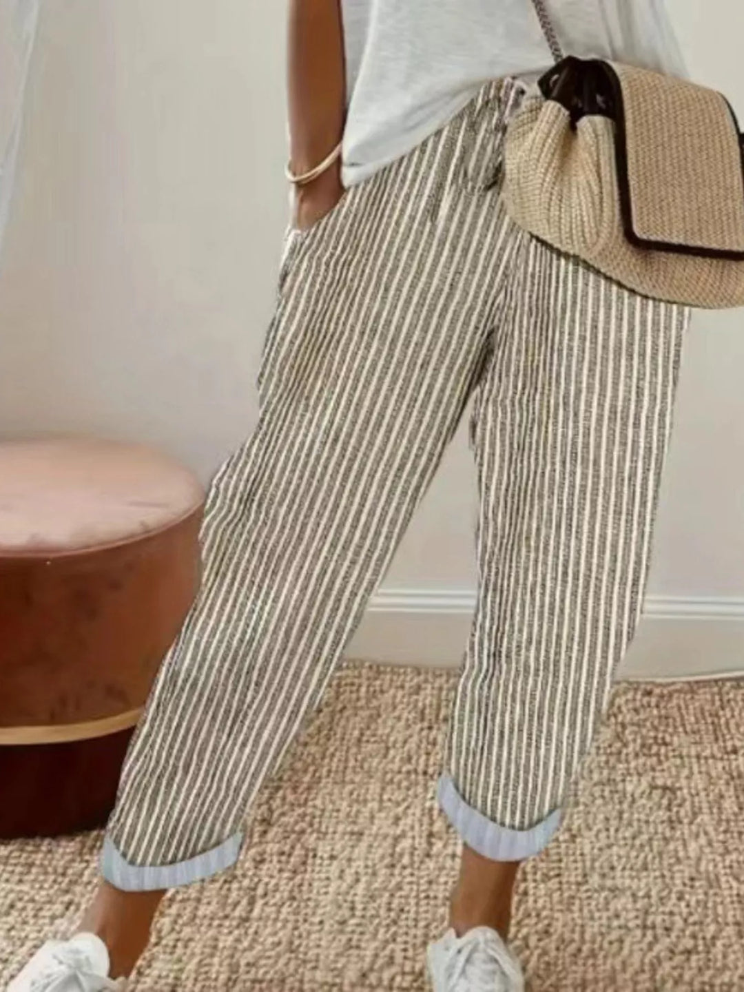 Beige striped cropped pants with rolled cuffs worn with white sneakers