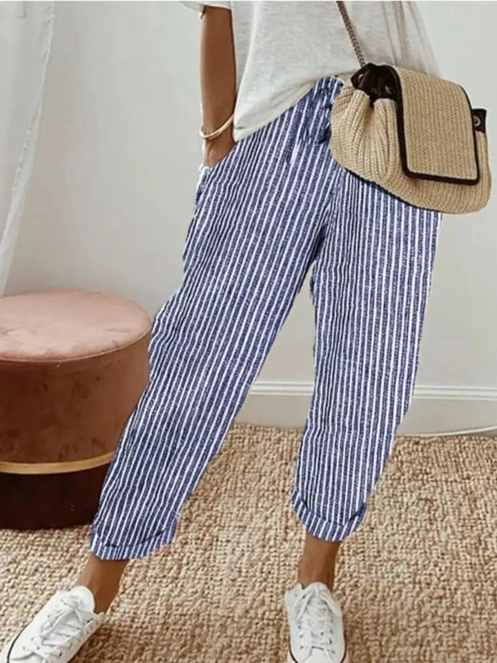 Blue striped cropped tapered pants with white tee and white sneakers