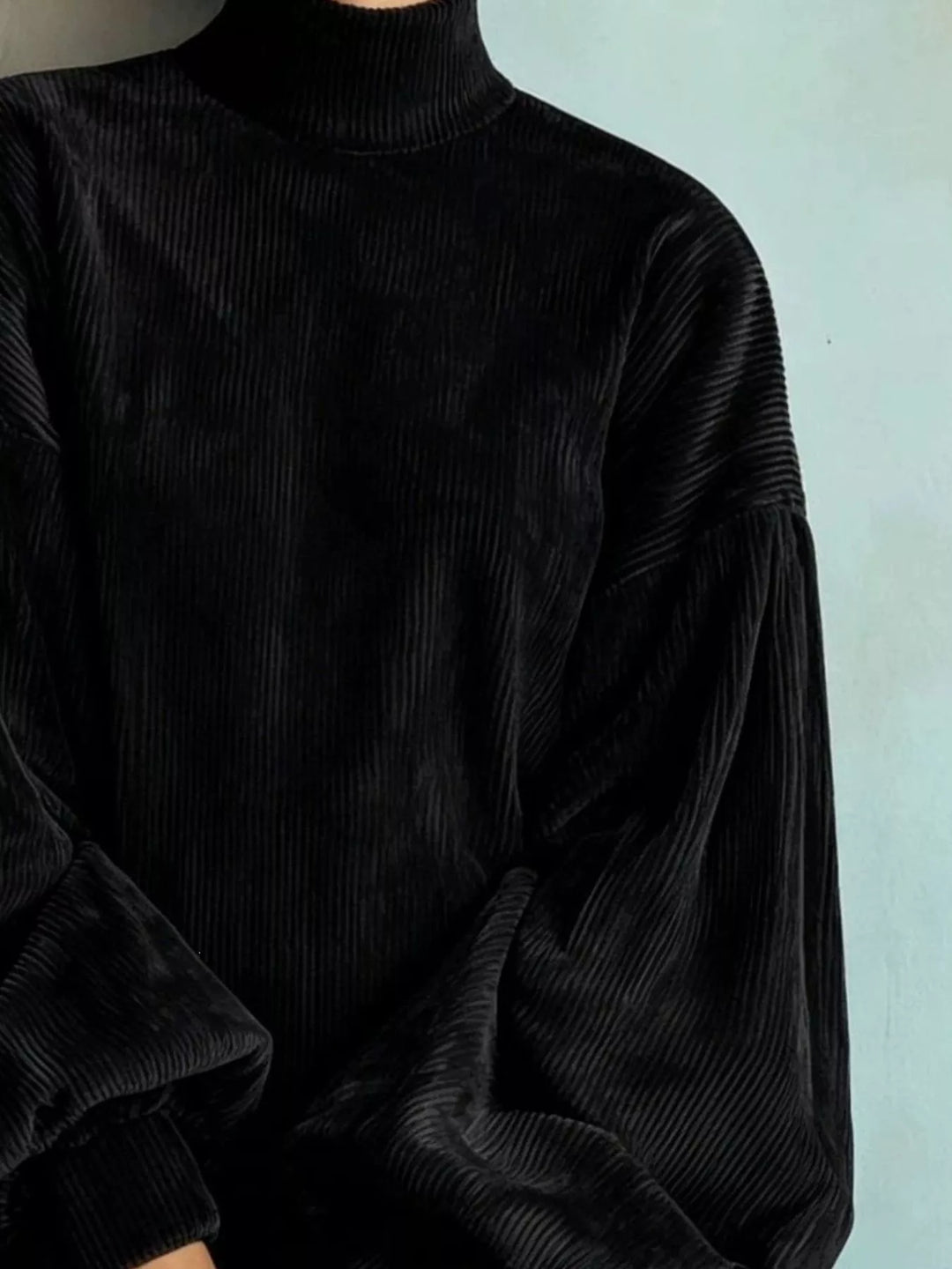 Black sweater dress worn on a model, showing the ribbed knit look