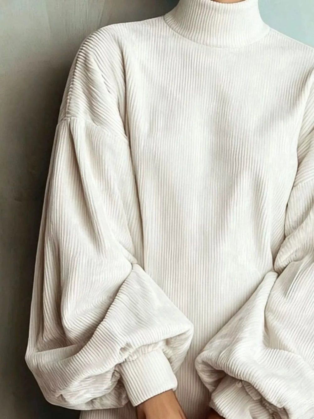 White sweater dress worn on a model, showing the ribbed knit look