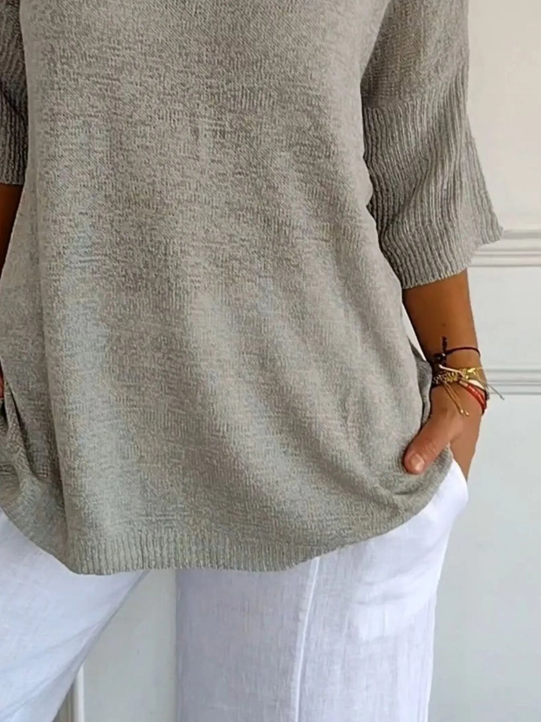 Gray sweater close-up of the ribbed 3/4 sleeve and loose hem