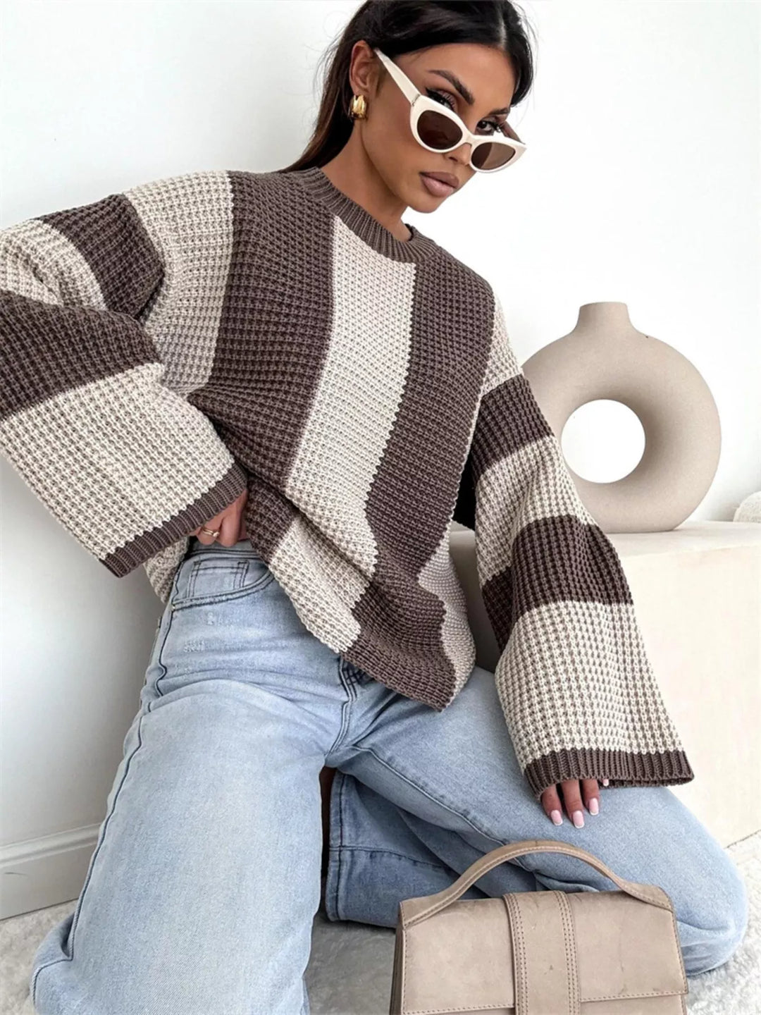 Beige and brown color block sweater, angled view with a handbag