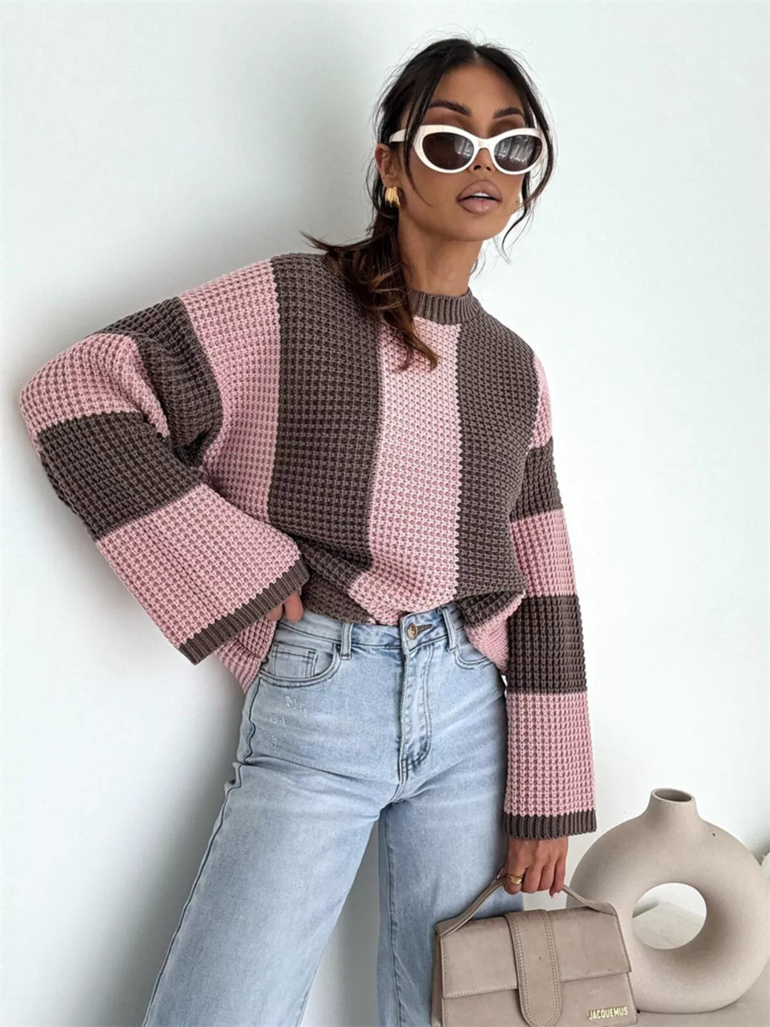 Oversized pink brown stripe sweater with light wash jeans and a handbag