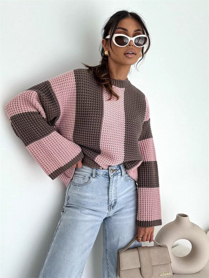 Oversized pink brown stripe sweater with light wash jeans and a handbag