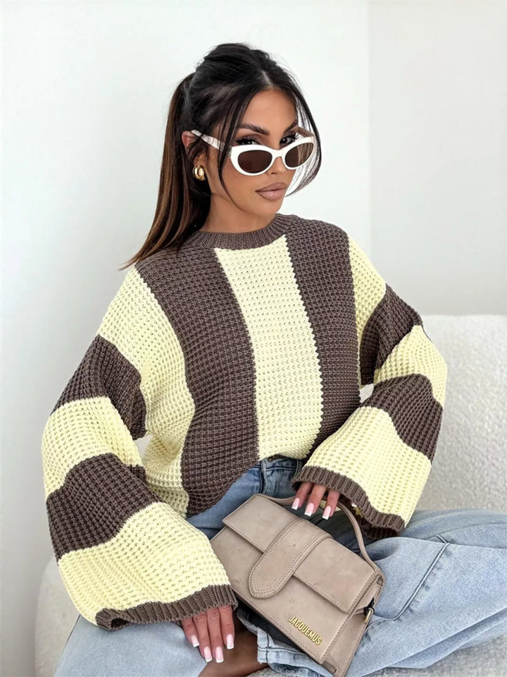 Yellow brown waffle knit sweater, seated with a taupe handbag and light jeans